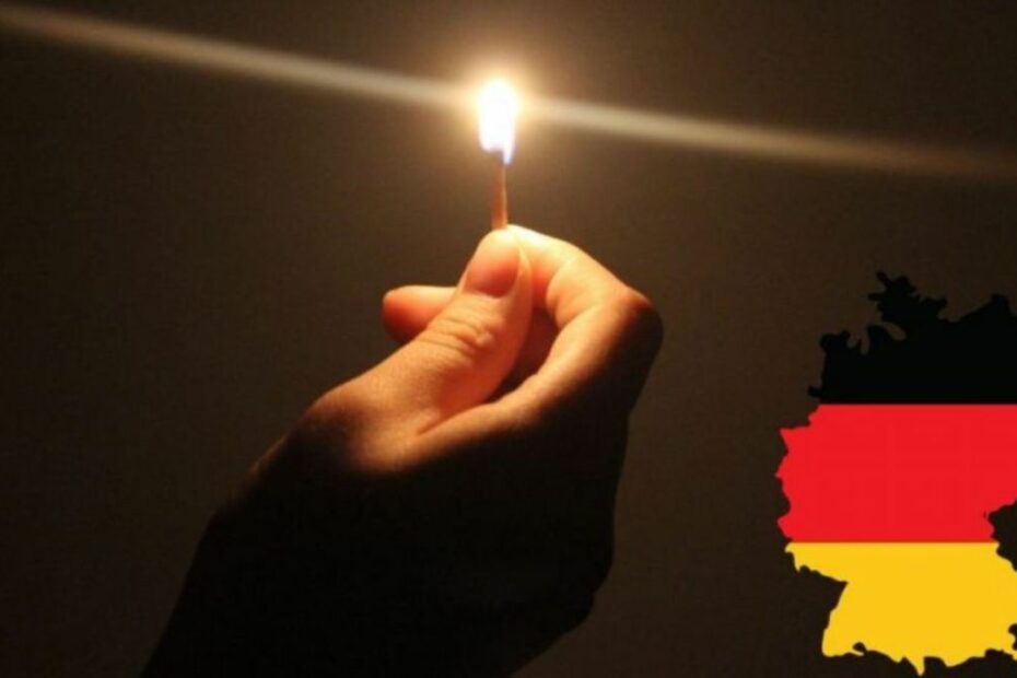 Ryzyko blackoutu w Niemczech Foto: Ręka z zapaloną zapałką i flaga niemiecka