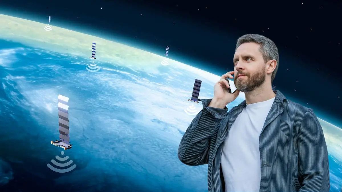 Telefony kompatybilne ze Starlink. Na zdjęciu mężczyzna rozmawaijący przez telefon na tle globu