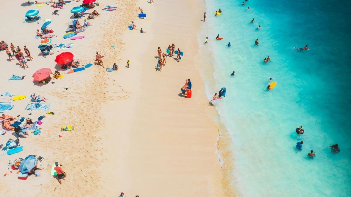 Najlepsze kremy przeciwsłoneczne dla dzieci Foto: turyści na plaży i w morzu