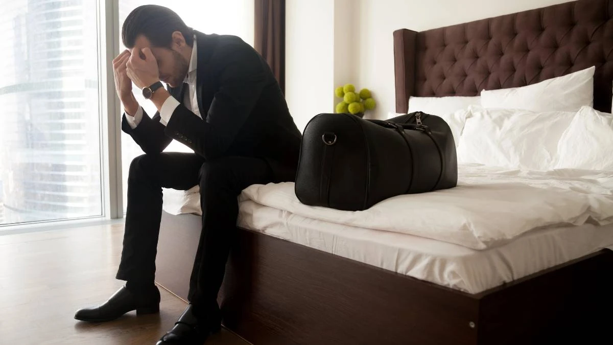 Jak rozpoznac zly hotel zdjecie mezczyzna siedzi na lozku w hotelu
