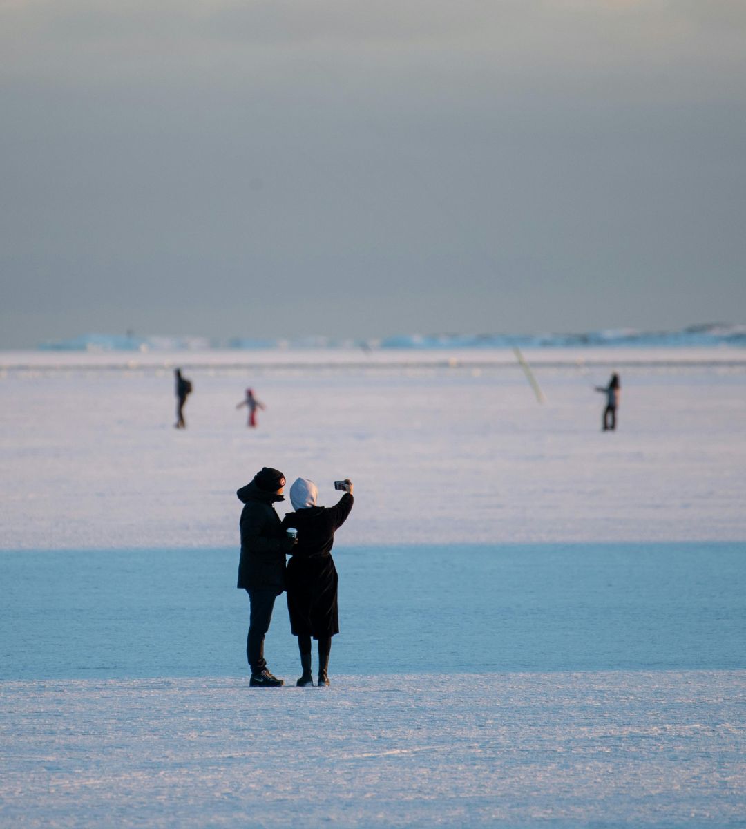 Estonia otwiera lodową autostradę Foto: ludzie chodzący po zamarzniętym akwenie