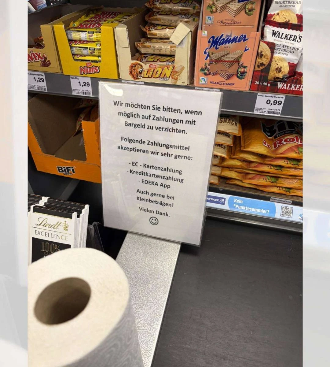 Tabliczka w sklepie Edeka z prośbą o ograniczenie płatności gotówką